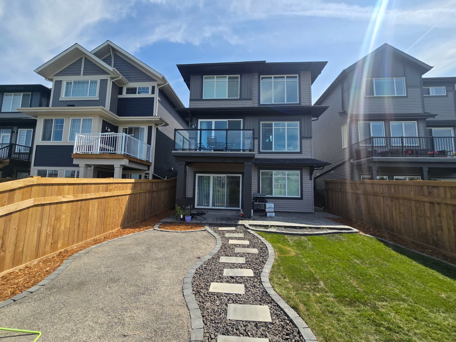 Large flat stepping stones through sod lawn — Edmonton