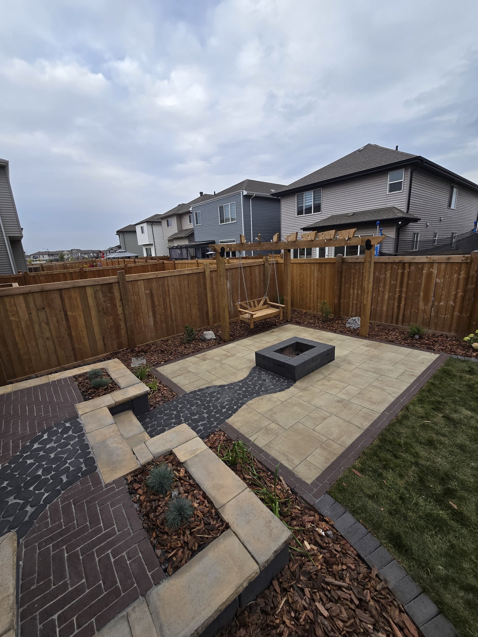 Square stone firepit patio with raised border — Edmonton