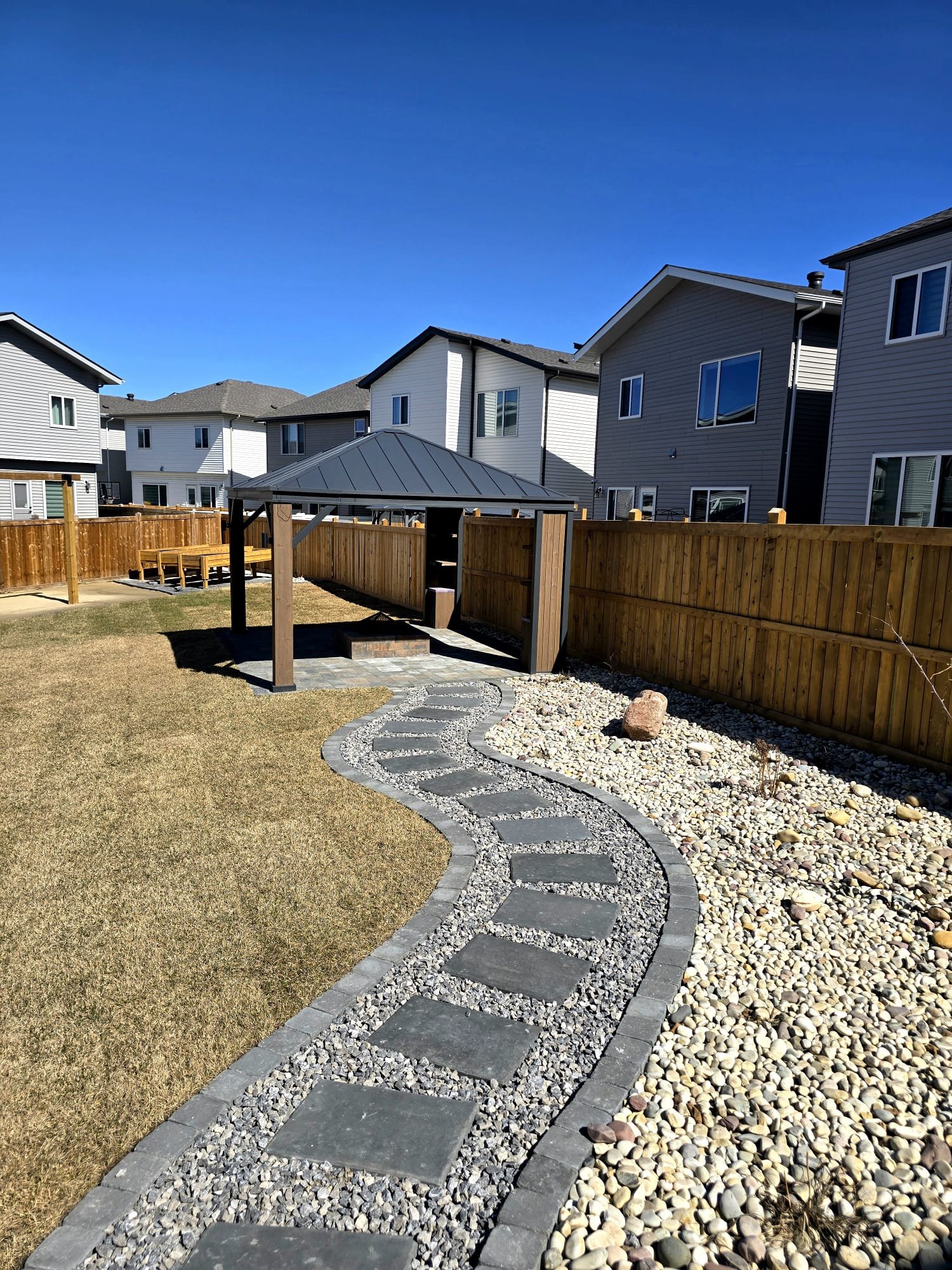 Rockscape pathway leading to gazebo in backyard — Edmonton
